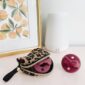 Pacifiers in leopard case beside white diffuser.