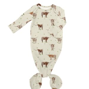 Infant gown with cow pattern on white background.