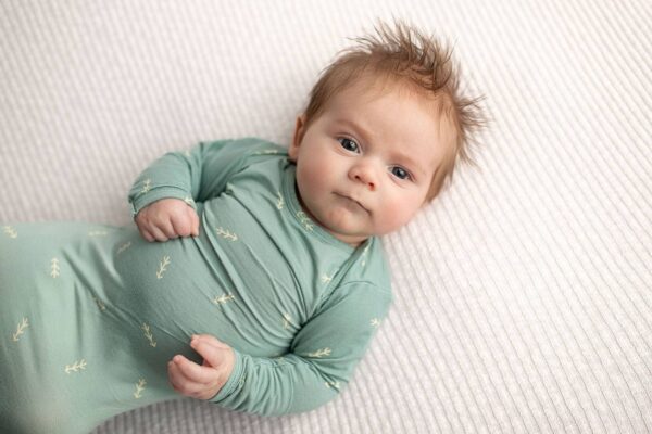 three little tots arrow print knotted newborn baby gown pajamas Baby in green outfit lying on blanket