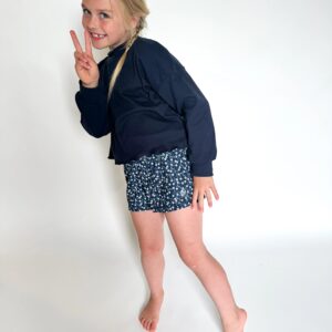 Child posing with peace sign and smile.