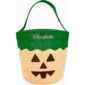 Halloween pumpkin treat bag with green handle.