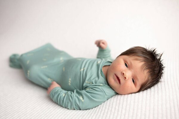 three little tots arrow print knotted newborn baby gown pajamas Newborn baby in green onesie lying down