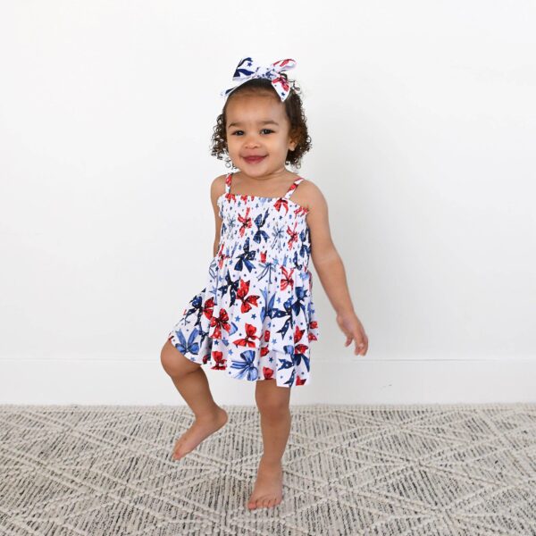 gigi and max eleanor bow clip bow 4th of july hair accessory Child in butterfly dress with matching headband smiles.