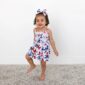 Child in butterfly dress with matching headband smiles.
