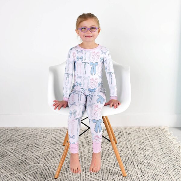 gigi and max samantha bows two piece no button bamboo kids lounge Child in bow-patterned pajamas sitting on chair