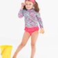 Girl in floral swimsuit with bucket and spade.