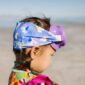 Child wearing unicorn swim goggles at beach