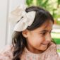 Child with large bow in hair, smiling