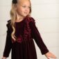 Child in red velvet dress with black bow