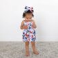 Child in butterfly print dress and matching headband.