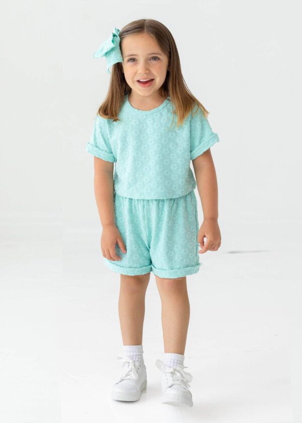 mabel + honey beachside two piece set Smiling child in teal outfit and bow
