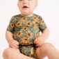 Baby wearing sunflower-patterned outfit, yellow bow.