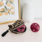Leopard case with maroon pacifiers, framed fruit art