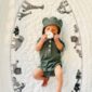 Baby in green onesie with animal-patterned blanket.