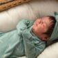 Sleeping baby in green outfit and headband