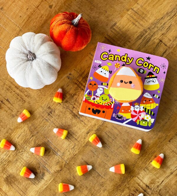 cottage door press candy corn halloween lift a flap finger puppet board book Candy corn book with pumpkins and candies on table.