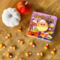 Candy corn book with pumpkins and candies on table.