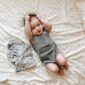 Baby lying on bed with pacifier