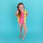 Smiling child in colorful swimsuit on blue background.