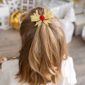 Child wearing a gold bow hair clip.