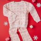 Festive candy cane print pajama set on red background.