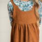 Child in floral shirt and brown dress