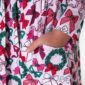 Child's hand in Christmas-themed dress pocket with bows.