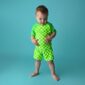 Toddler in green checkered outfit on blue background.