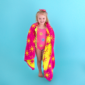 Smiling girl in swimsuit with sun-pattern towel.