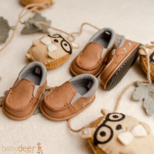 Brown baby shoes with decorative plush animals.
