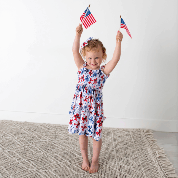 gigi and max eleanor bow clip bow 4th of july hair accessory Child celebrating with American flags on Independence Day.