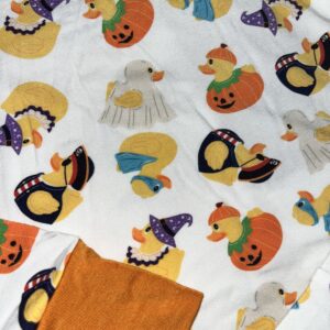 Festive rubber duck pajamas with Halloween designs.