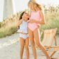 Two girls in swimsuits smiling on beach