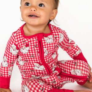 Smiling baby in red checkered pajamas.