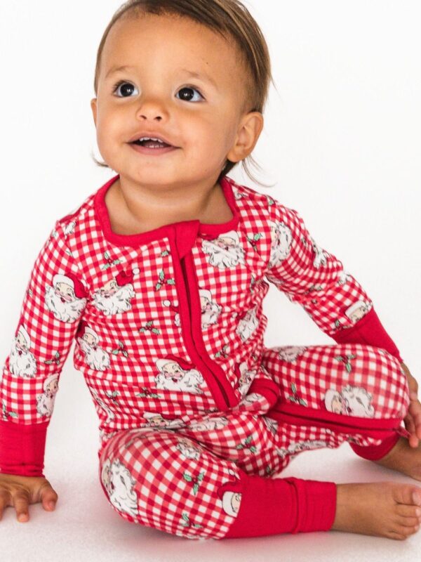 Smiling baby in red checkered pajamas.