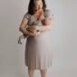 Mother holding newborn in neutral outfit.