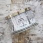 White Birch scented candle on birch background.