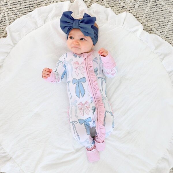 gigi and max samantha bows ruffle zip bamboo sleeplies little outfit Baby in bow outfit on white blanket.