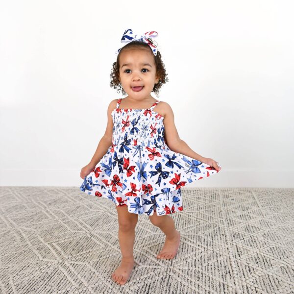 gigi and max eleanor bow clip bow 4th of july hair accessory Child in butterfly dress and matching bow smiling.