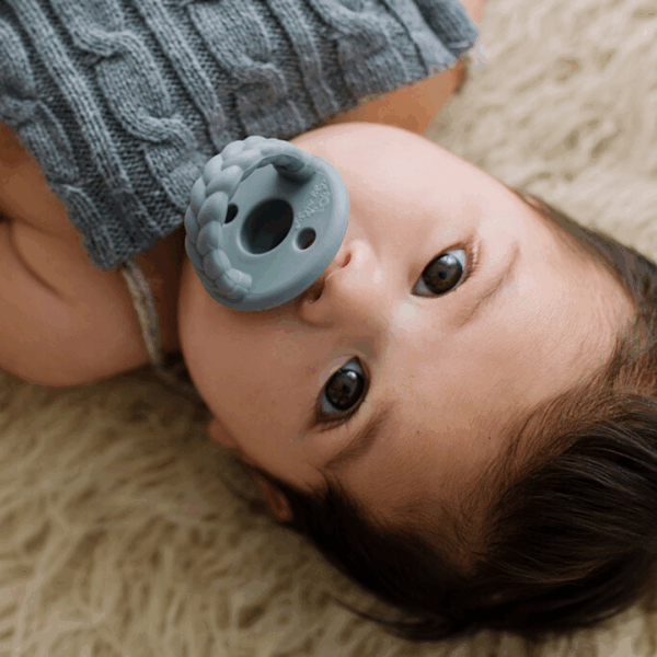 itzy ritzy sweetie soother™ pacifier sets (2 pack): agave + succulent cables Baby with pacifier laying on soft blanket