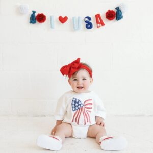 Baby in patriotic outfit with 'I ❤️ USA' banner.