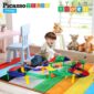 Child playing with colorful toy tracks on carpet.