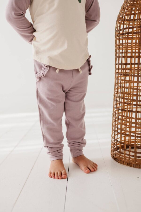 babysprouts clothing company girl's joggers bamboo Child wearing purple pants, barefoot on wooden floor