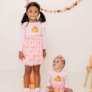 Children in pumpkin print dresses for fall