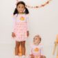 Children in pumpkin print dresses for fall