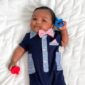 Baby in formal outfit with bow tie and pacifier.