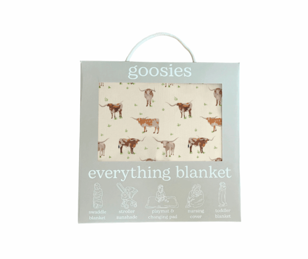 Cow-patterned blanket packaging with multi-use icons.