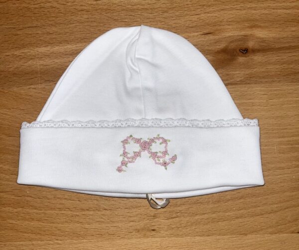 White baby hat with pink floral embroidery