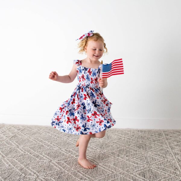 gigi and max eleanor bow clip bow 4th of july hair accessory Child in dress holding American flag