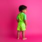 Child in checkered outfit on pink background